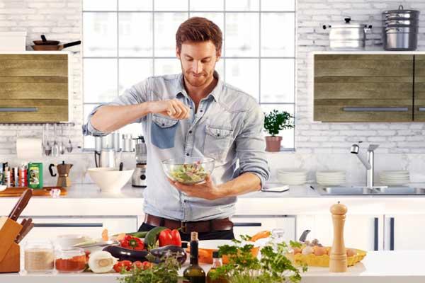 Мужские продукты питания - мужчина колдует на кухне Мужские продукты питания - мужчина колдует на кухне